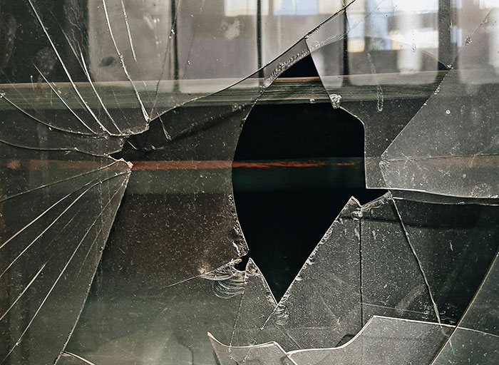 Broken glass window with sharp cracks and jagged holes, symbolizing the psychologists patients who genuinely scared them concept.