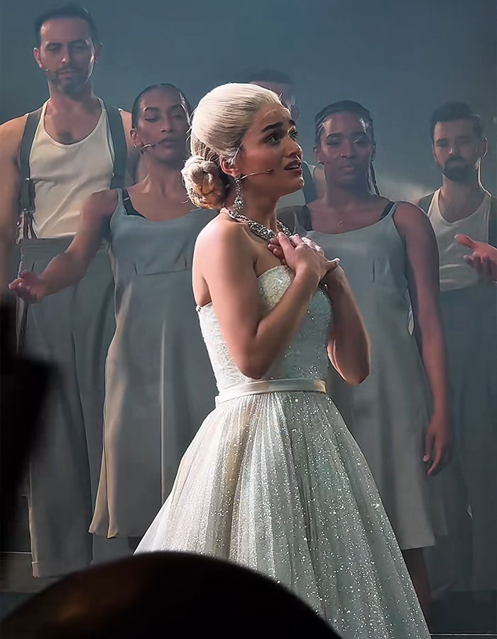 Rachel Zegler performing on stage with backup dancers, sparking outrage among fans during a live show event.