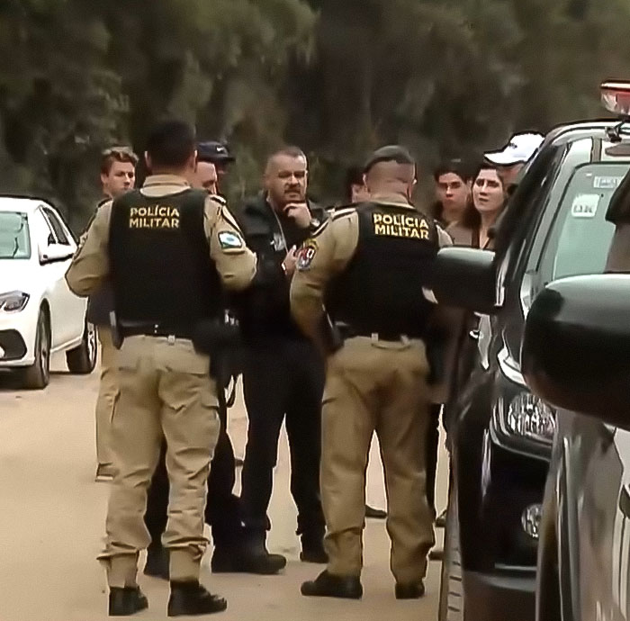 Police officers and bystanders gather at a scene related to the beauty queen strangled by family friend and former teacher case.