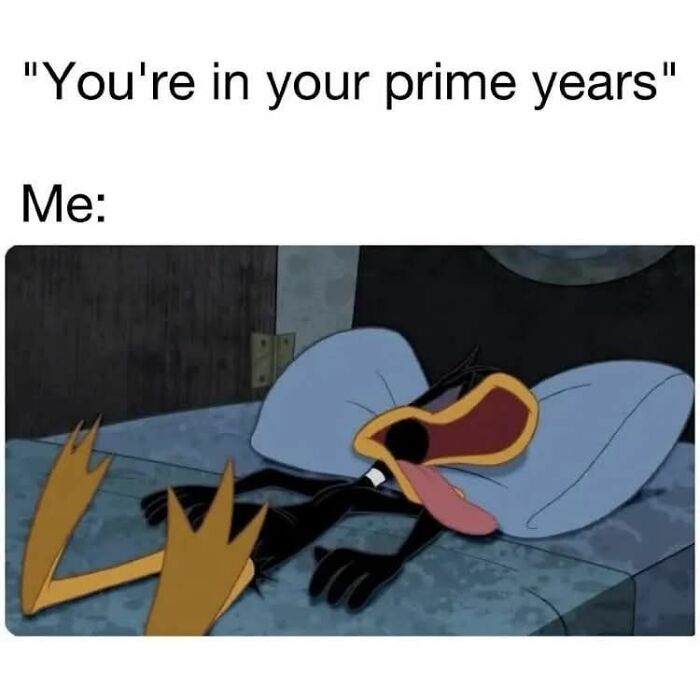 Cartoon character lying exhausted on bed with tongue out, illustrating hilarious memes to help you decompress.