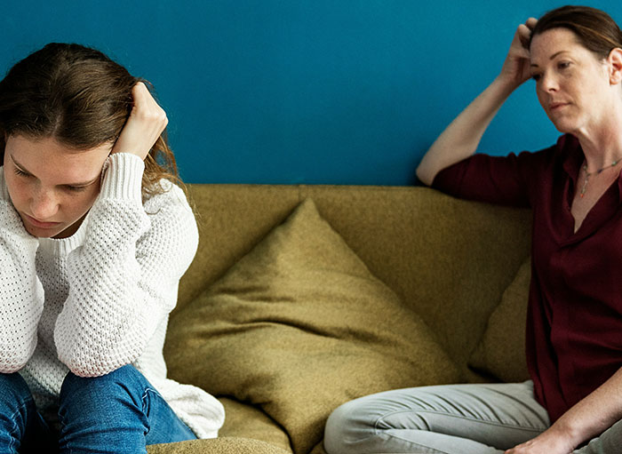 Two women sitting apart on a couch, one looking upset after refusing to babysit niece due to SIL's rudeness. Two women sitting apart on a couch, one looking upset after refusing to babysit niece due to SIL's rudeness.