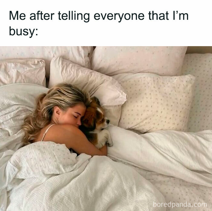 Woman lying in bed hugging a dog, illustrating relatable memes about the chaos of navigating the world as a woman today.
