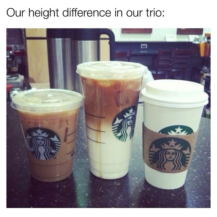 Three Starbucks coffee cups of varying sizes on a table, illustrating relatable memes capturing the chaos of womanhood today.