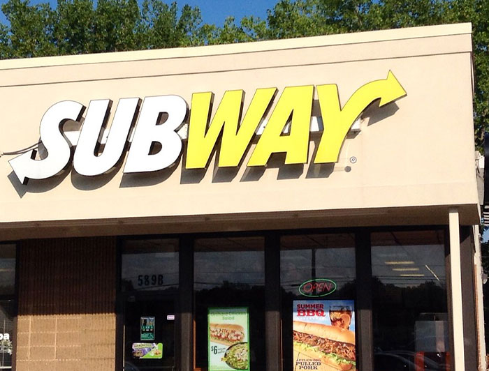 Subway storefront with promotional sandwich posters, illustrating chain restaurant employees' warnings about menu items to avoid.