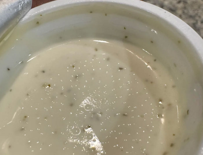 Close-up of a creamy sauce in a container, highlighting a common item chain restaurant employees warn against ordering.