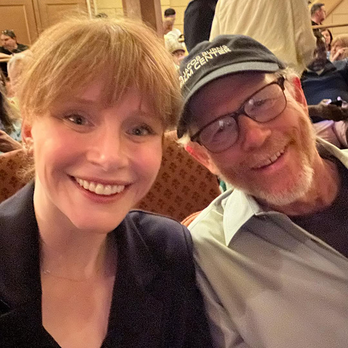Bryce Dallas Howard and Ron Howard smiling together at an indoor event, highlighting nepo baby status.