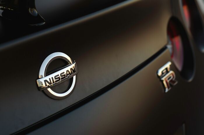 Close-up of a Nissan car emblem highlighting middle class lifestyle through relatable car brand choices shared by netizens.