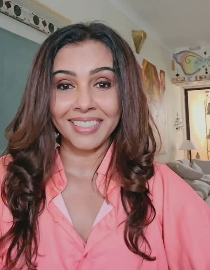 Actress smiling indoors, sparking outrage after accusing Air India crash miracle survivor of lying.