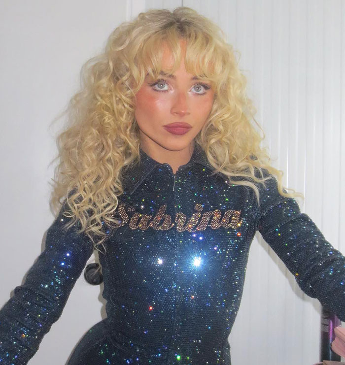 Sabrina Carpenter with curly blonde hair in a sparkly outfit, related to tone deaf and degrading album cover controversy.