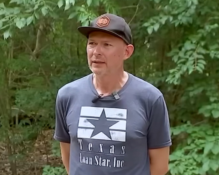 Man wearing a Texas t-shirt and cap speaking outdoors with trees in the background about Bagpipe Karen instant karma incident.