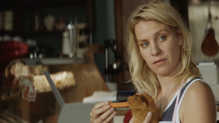 Woman with blonde hair holding a puppet in a dimly lit room, capturing a scene reflecting tragic losses in TV shows.