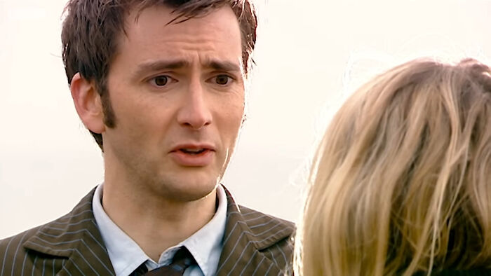 Man with a concerned expression talking to a woman, depicting one of the most tragic losses in TV shows.