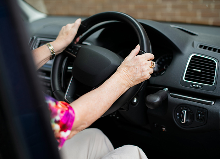 Older person gripping car steering wheel, symbolizing the weight of disturbing deathbed confessions and guilt they lived with.