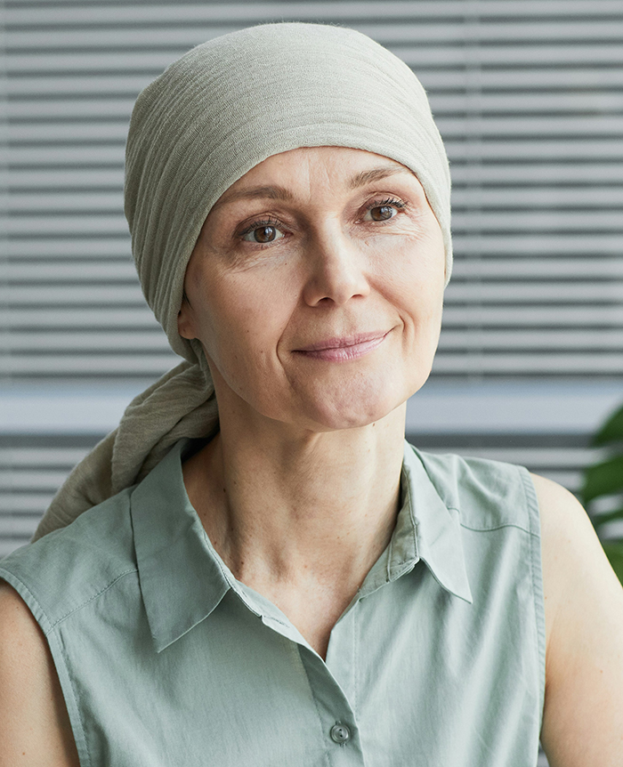 Woman wearing a headscarf with a gentle smile, reflecting on disturbing deathbed confessions and lingering guilt.