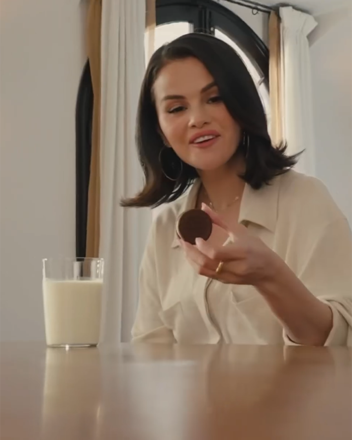 Woman holding Oreo cookie with a glass of milk, related to Oreo's Selena Gomez flavored cookie release and reactions. Woman holding Oreo cookie with a glass of milk, related to Oreo's Selena Gomez flavored cookie release and reactions.