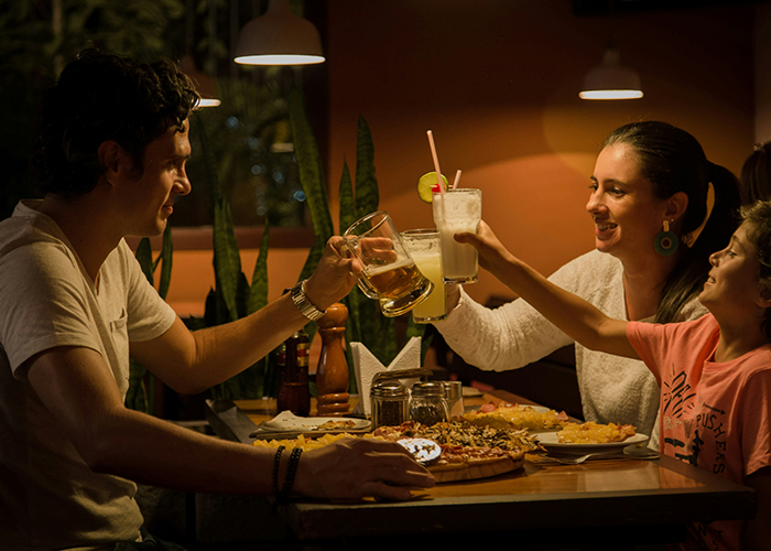 Family enjoying a meal and drinks together, celebrating with a toast during a cozy dinner gathering.