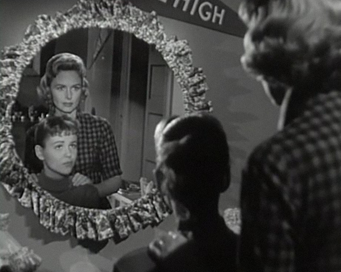 Black and white image of iconic sitcom legend and young boy reflected in mirror during a rare public outing.