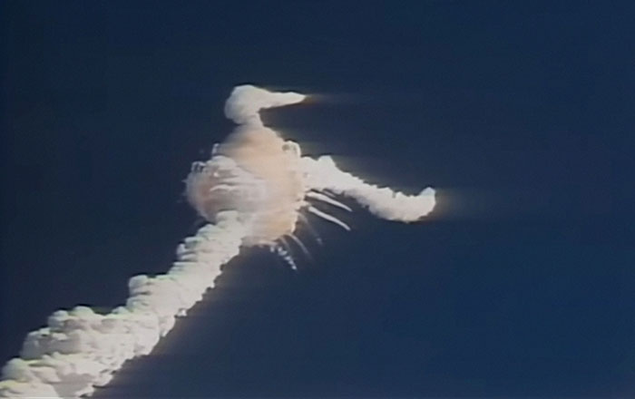 Space shuttle explosion creating a cloud trail in the sky, one of the most shocking moments on live television.