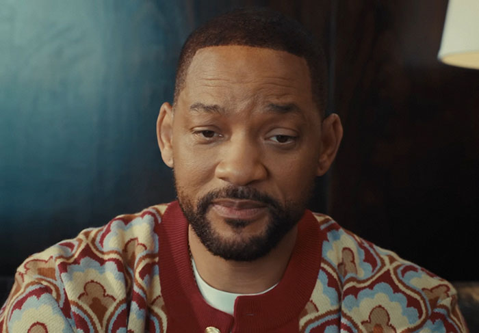 Man in patterned sweater with thoughtful expression, representing shocking moments on live television for Gen X viewers.