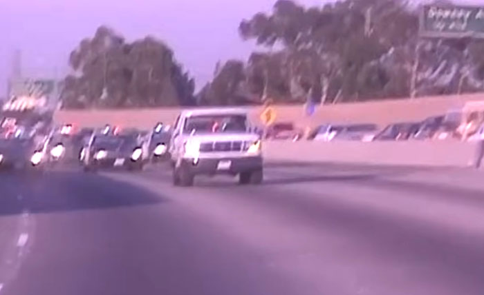 White truck driving on a busy highway during daylight, illustrating shocking moments caught on live television.