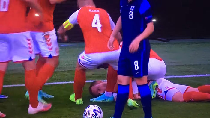 Soccer players reacting to a shocking moment on live television during a tense match on the field.