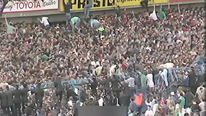 Massive crowd at a live event, capturing one of the most shocking moments on live television impacting Gen X culture.