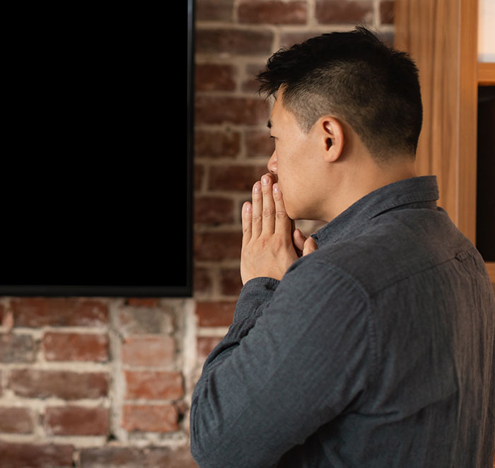 Man watching TV with worried expression, reflecting on shocking moments on live television related to Gen X culture.