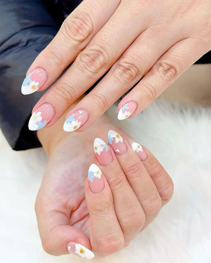 Short French tip nails featuring floral designs on natural nails, showcasing stylish nail art for 2025 trends. Short French tip nails featuring floral designs on natural nails, showcasing stylish nail art for 2025 trends.