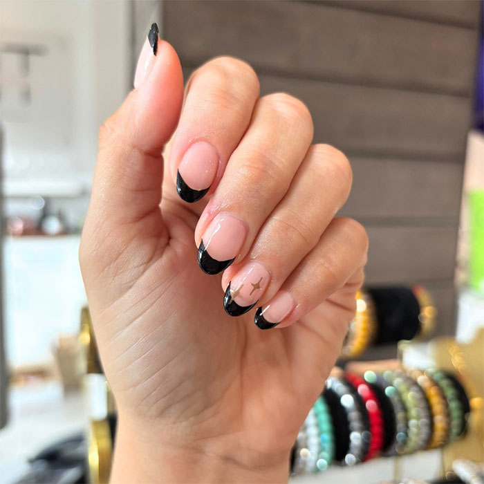 Short French tip nails with black design and star accent, showcasing stylish nail art for 2025 trends. Short French tip nails with black design and star accent, showcasing stylish nail art for 2025 trends.