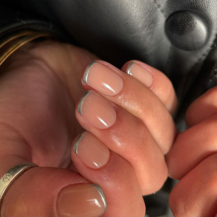 Short French tip nails with silver design on natural nails, showcasing stylish nail art for 2025 trends. Short French tip nails with silver design on natural nails, showcasing stylish nail art for 2025 trends.