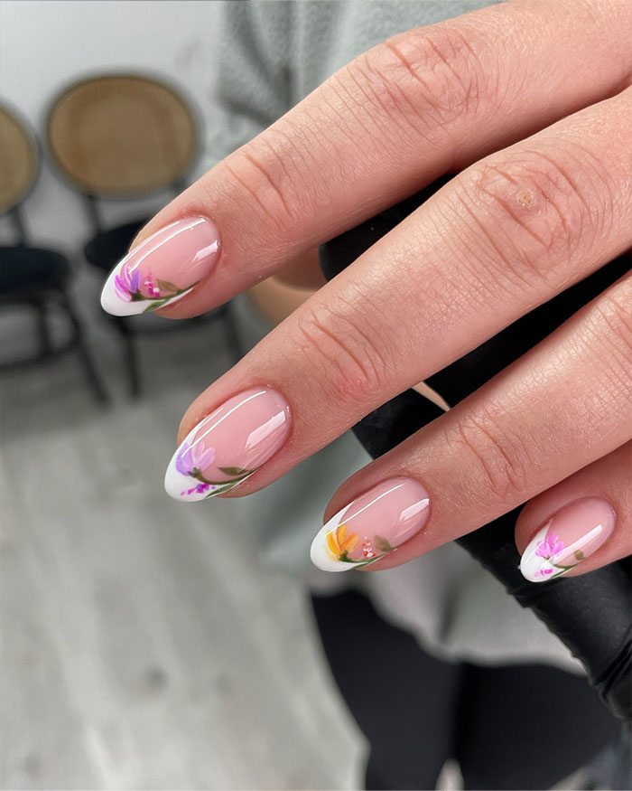 Short French tip nails with floral design on natural nails, showcasing stylish nail art trends for 2025. Short French tip nails with floral design on natural nails, showcasing stylish nail art trends for 2025.