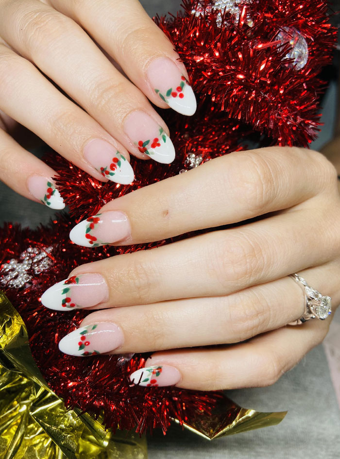 Short French tip nails with festive berry design on almond shape, showcasing stylish nail art for 2025 trends. Short French tip nails with festive berry design on almond shape, showcasing stylish nail art for 2025 trends.