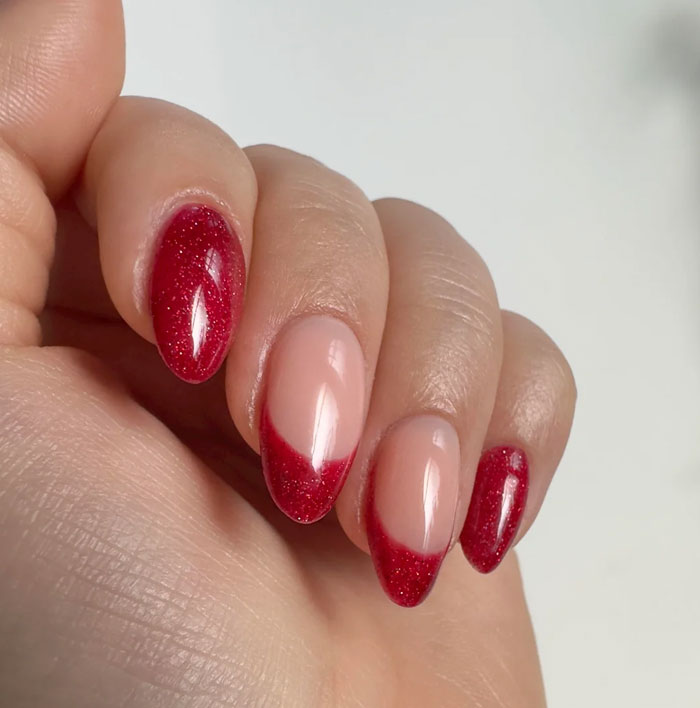 Close-up of short French tip nails with red glitter design, showcasing stylish manicure trends for 2025. Close-up of short French tip nails with red glitter design, showcasing stylish manicure trends for 2025.
