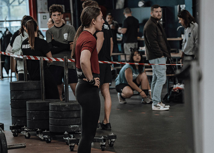 Woman at gym focused on workout while gym guy tries to fist bump her despite her intent not to make friends