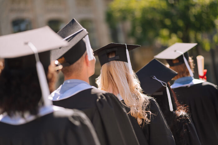 Group of graduates in caps and gowns seen from behind, illustrating moments when being shy made social situations worse.