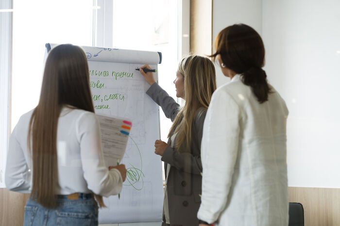 Three women collaborating in a bright office, illustrating moments when being shy made communication 10x worse.