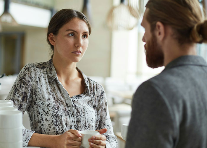 Woman with serious expression holding a cup in a tense conversation, hinting at sister sabotage during birthday dinner discussion. Woman with serious expression holding a cup in a tense conversation, hinting at sister sabotage during birthday dinner discussion.