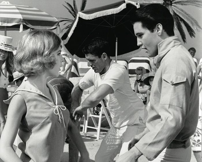 Black and white photo of iconic sitcom legend interacting with people at a beach setting during a rare public outing.