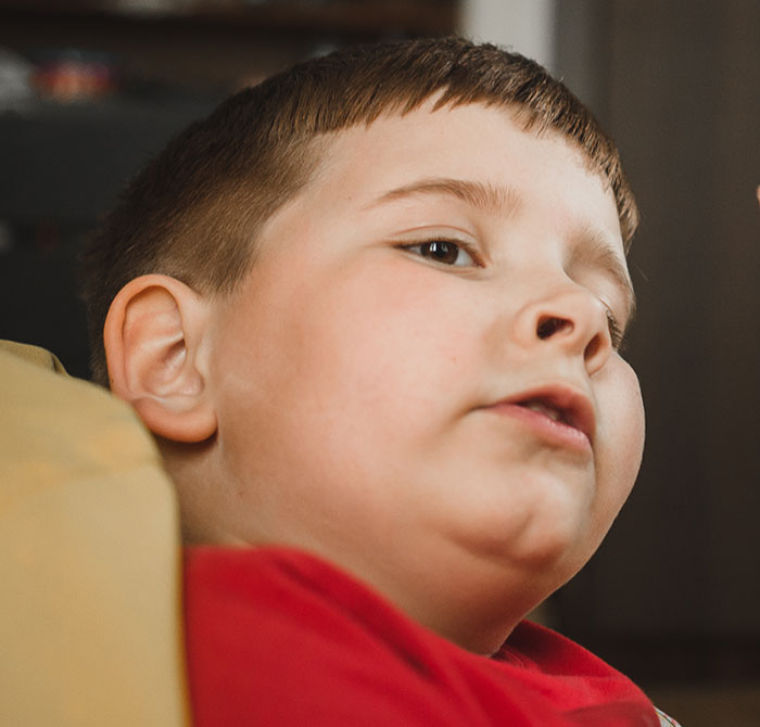 Close-up of a young boy in a red shirt lying down, illustrating kids lies that started off silly and got real.