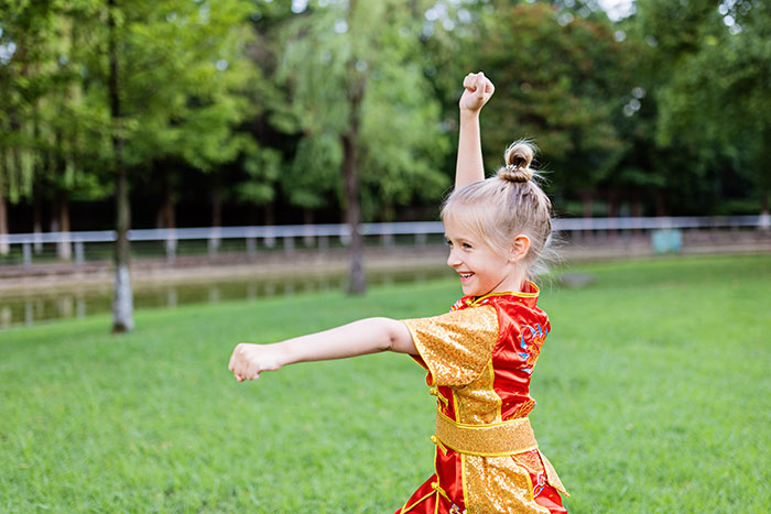 Young girl in colorful costume playing outside, capturing the innocence of kids' lies and imaginative stories.