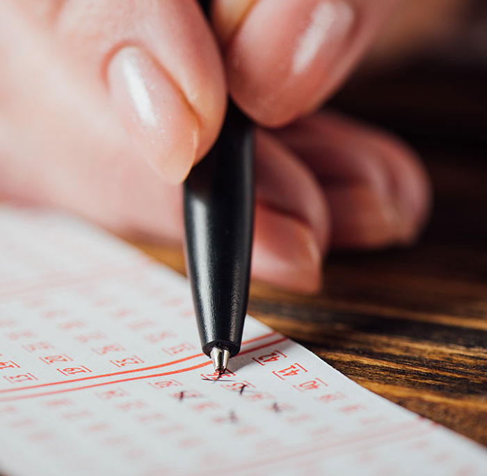 Close-up of a hand marking answers on a test paper, illustrating kids lies that started off silly and got way too real.