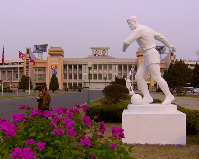 Statue of soccer player near a stadium in North Korea, highlighting control measures linked to smuggled smartphone insights.