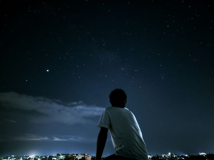 Person in a white shirt stargazing at night, reflecting on things people thought everyone knew but don’t.