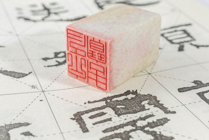 Seal stamp on paper with Asian characters, symbolizing culture and challenges of being big in Japan for foreigners.