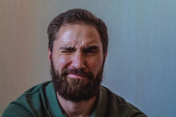 Man with a beard showing frustration after strangers use his patio as their own during his time off.