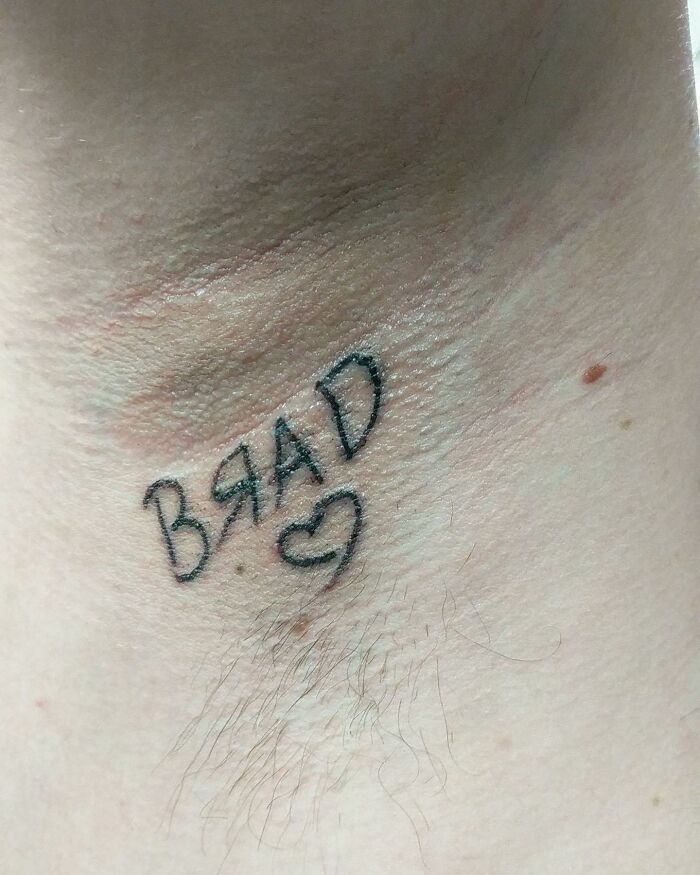 Close-up of a bizarre tattoo misspelling the word Brad with a heart, showcasing strange choices people made while getting tattoos.