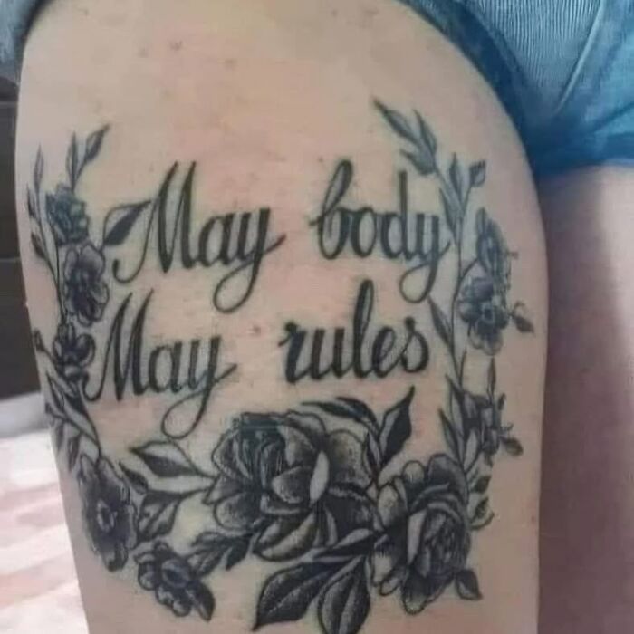Tattoo on thigh with floral design and text containing a misspelled phrase showcasing bizarre choices in tattoos.