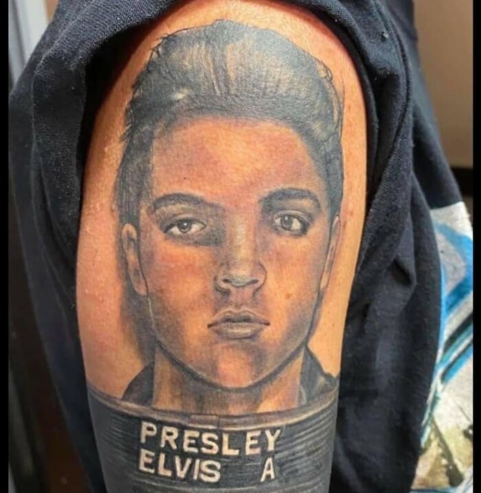 Tattoo of an unusual portrait of Elvis Presley on a person's upper arm, showcasing bizarre tattoo choices.