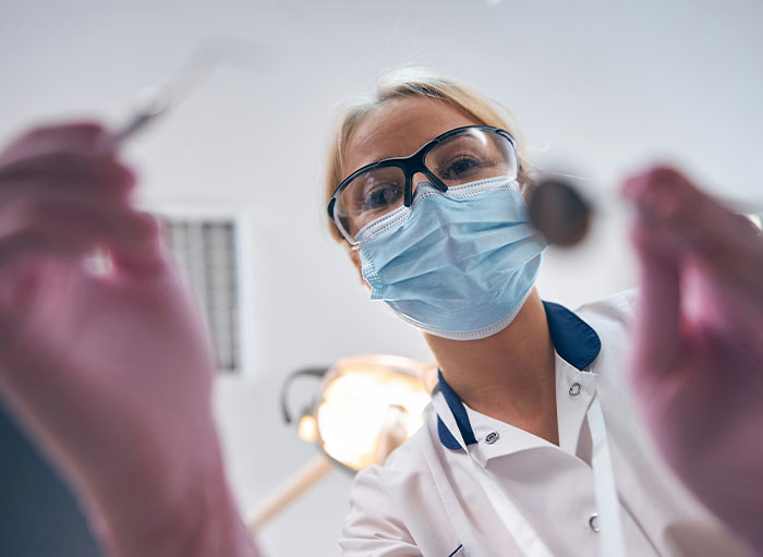 Surgeon wearing protective glasses and mask performing a medical examination related to weird facts about the human body