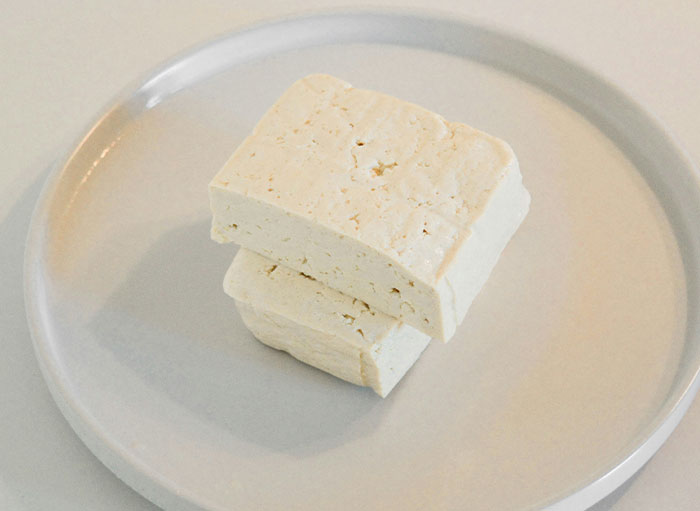 Two blocks of tofu on a round white plate illustrating protein sources related to the human body facts shared by surgeons.